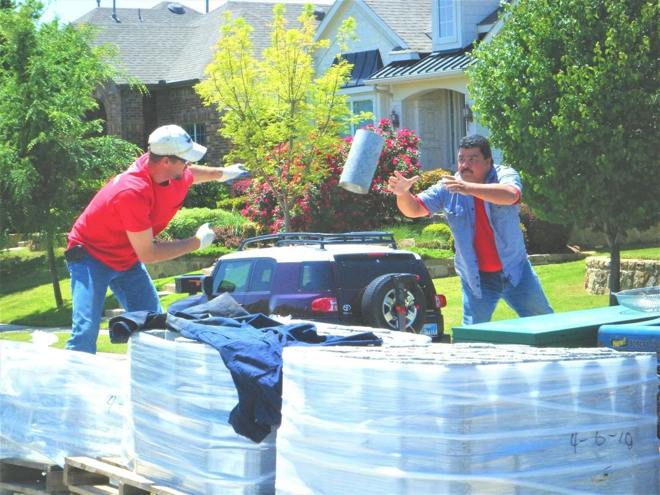 Workers passing materials on a sunny day.