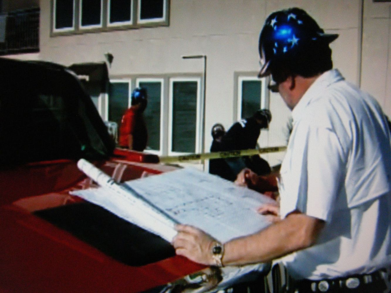 Man in hard hat with building plans