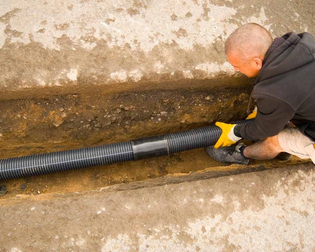 Worker installing a drainage pipe