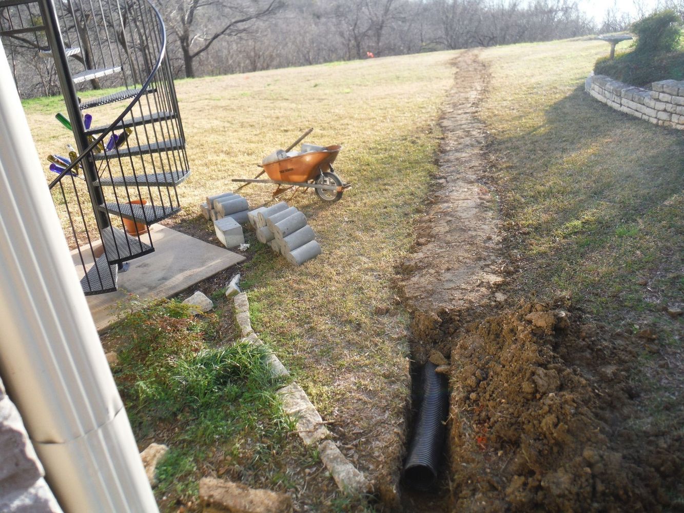 Outdoor drainage project near spiral stairs
