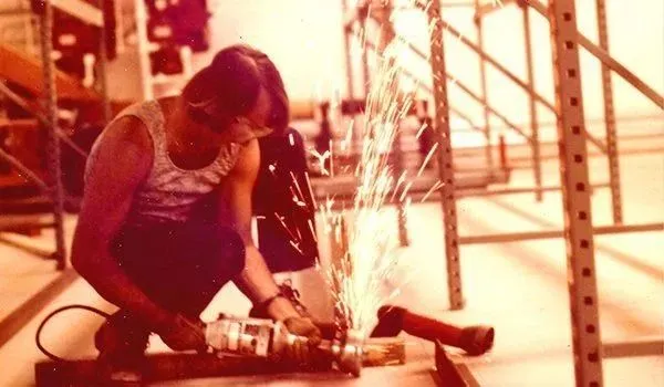 Worker using angle grinder in workshop